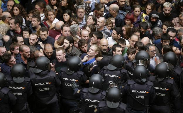 Antidisturbios de la Policía Nacional forman ayer un cordón de seguridad en los alrededores del colegio Ramón Llull de Barcelona.