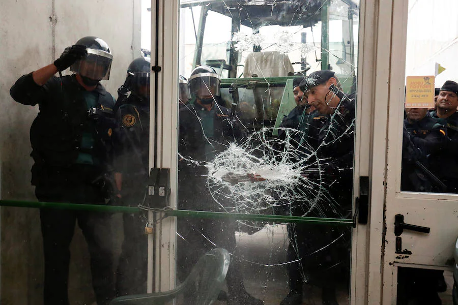 Agentes de la Guardia Civil fuerzan la puerta de un colegio electoral para acceder a su interior.