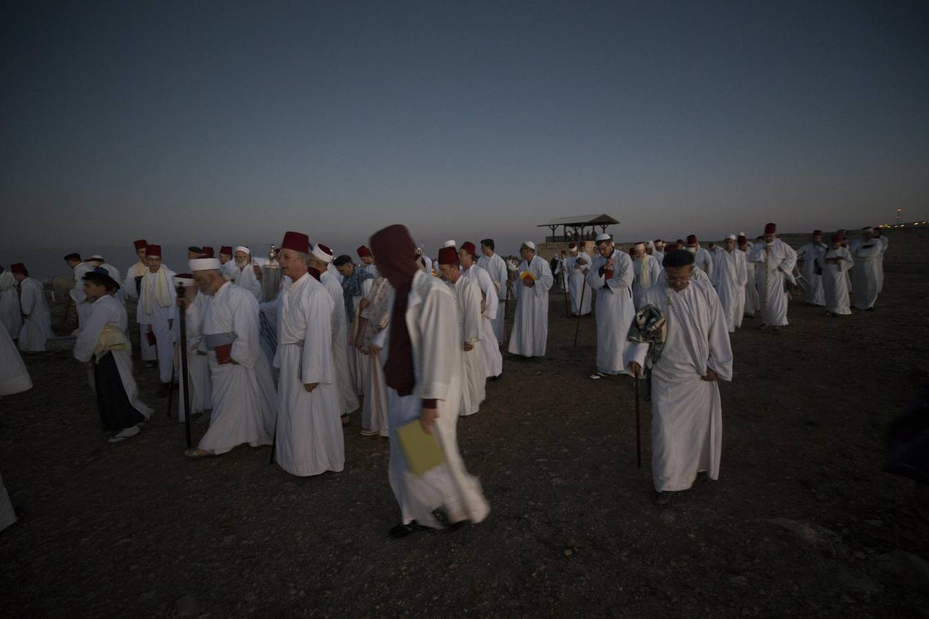 Miembros de la comunidad samaritana caminan hacia la cima del Monte Guerizín al amanecer en Nablus (Palestina), con motivo de la celebración del Sukot o fiesta de los tabernáculos.