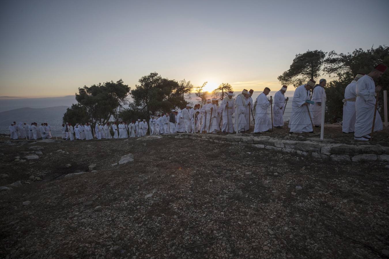 Miembros de la comunidad samaritana caminan hacia la cima del Monte Guerizín al amanecer en Nablus (Palestina), con motivo de la celebración del Sukot o fiesta de los tabernáculos.