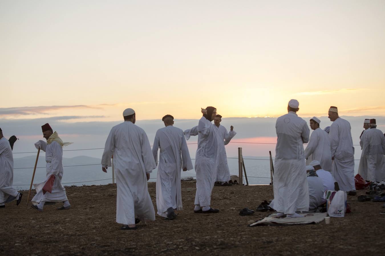 Miembros de la comunidad samaritana caminan hacia la cima del Monte Guerizín al amanecer en Nablus (Palestina), con motivo de la celebración del Sukot o fiesta de los tabernáculos.