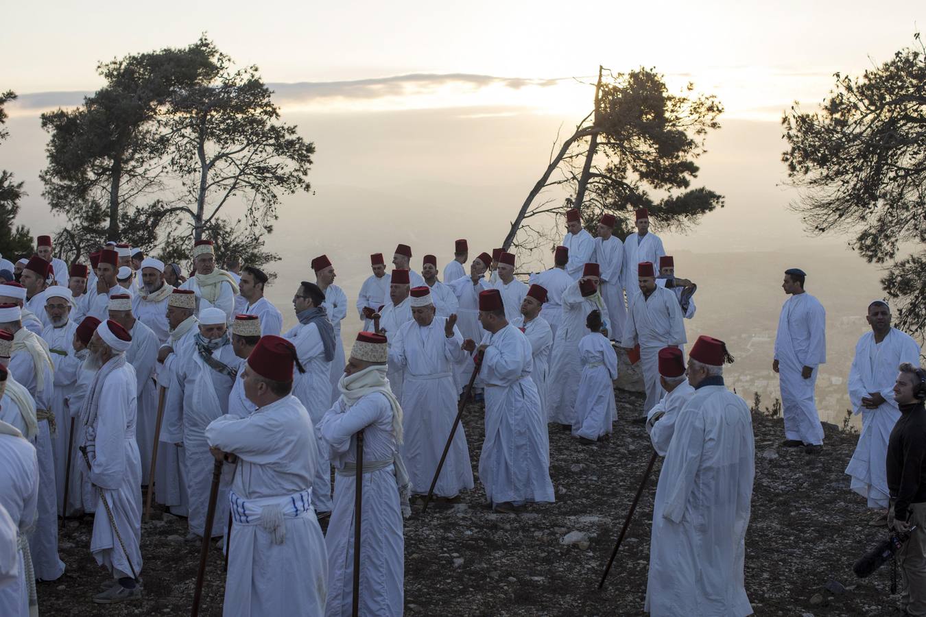 Miembros de la comunidad samaritana caminan hacia la cima del Monte Guerizín al amanecer en Nablus (Palestina), con motivo de la celebración del Sukot o fiesta de los tabernáculos.