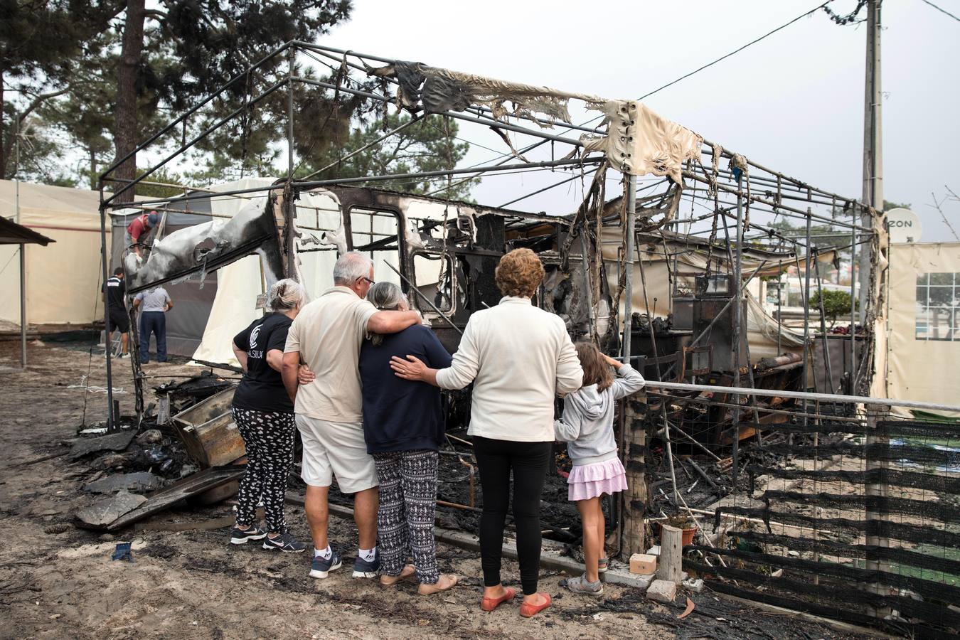 Vecinos observan los daños tras un incendio forestal en un camping en Marinha Grande, en el centro de Portugal,
