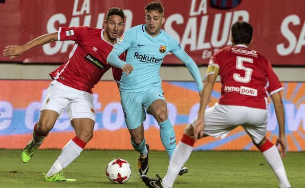 El jugador del F.C Barcelona Gerard Deulofeu (c) conduce el balón ante el jugador del Real Murcia Juanra (i).