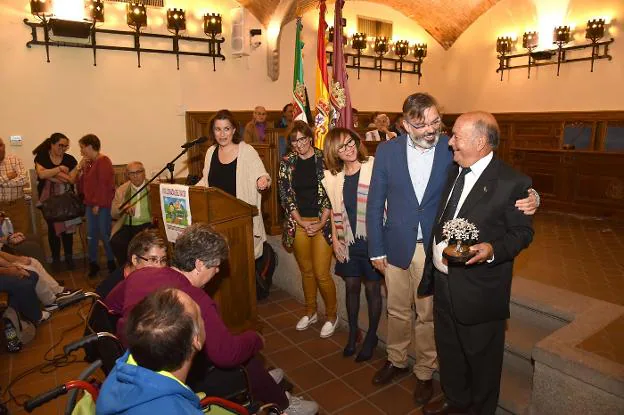 El alcalde abraza al homenajeado, Valeriano Pablos, con la encina plateada en la mano. :: david palma