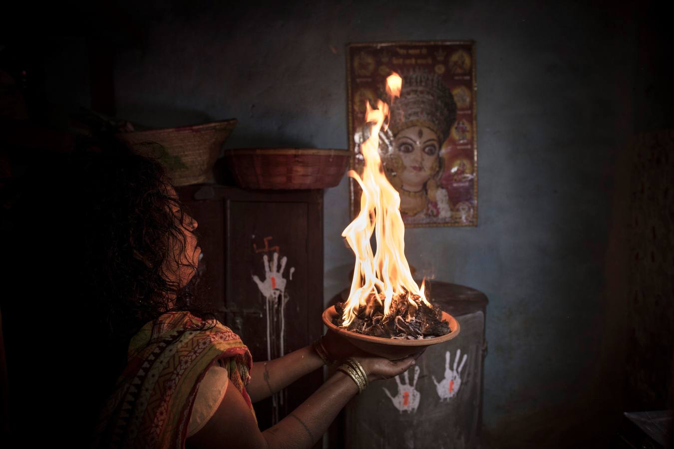 Un grupo de mujeres que creen haber sido poseídas por espíritus malignos danzan y cantan mantras en la víspera de una noche de luna llena, mientras se congregan para la celebración del "Festival de los fantasmas", en las orillas del río Kamala en el distrito de Danusha (Nepal), el 3 de noviembre de 2017. La celebración tiene siglos de tradición y tiene lugar anualmente en la noche de luna llena de noviembre. Miles de personas se congregan para llevar a cabo rituales de sanación conducidos por chamanes, en los que se "cura" a personas poseídas de espíritus malignos que acechan el porvenir de las familias.