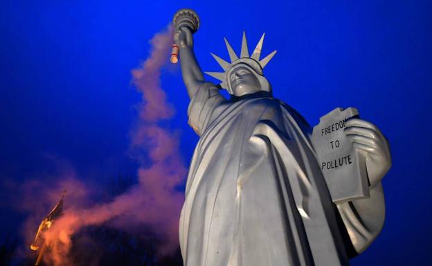 Una réplica de la Estatua de la Libertad con humo es utilizada como protesta en la cumbre. 