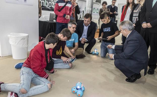 Varios niños interactúan con robots en la primera jornada de RoboRAVE 2017 bajo la mirada de Vara y Fragoso.
