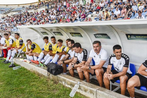 Banquillo del Badajoz, con Marrero al frente. Detrás, la afición blanquinegra. :: hoy