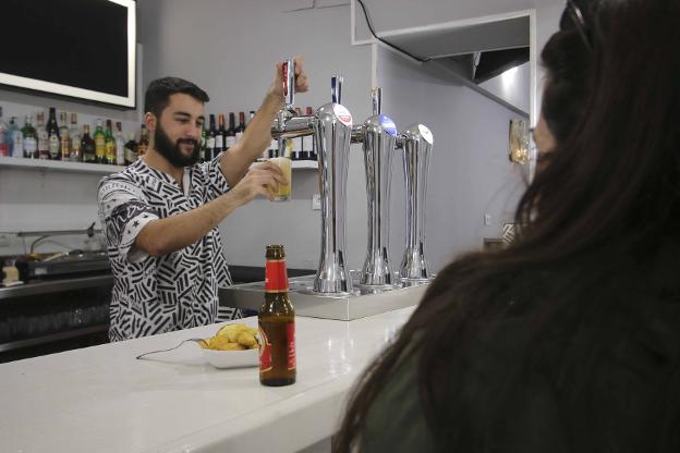 Un camarero sirve una cerveza en un bar de Mérida. :: j. m. romero