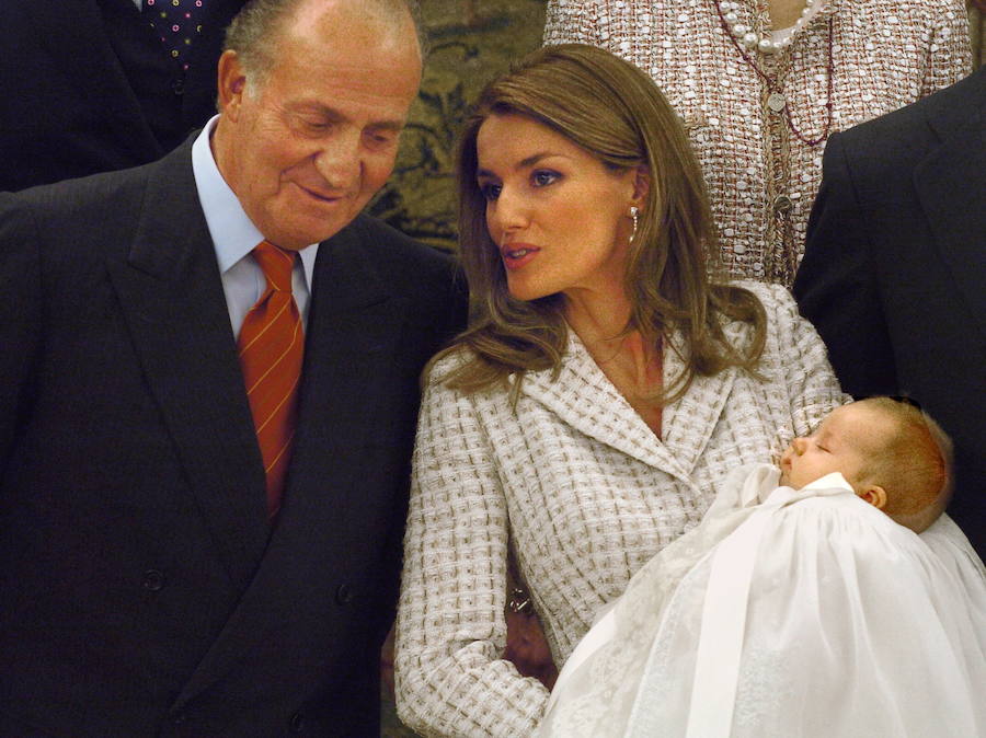 La Princesa de Asturias, con la infanta Leonor en brazos, charla con el rey Juan Carlos durante la sesión fotográfica en el Palacio de la Zarzuela con motivo del bautizo de la Infanta.