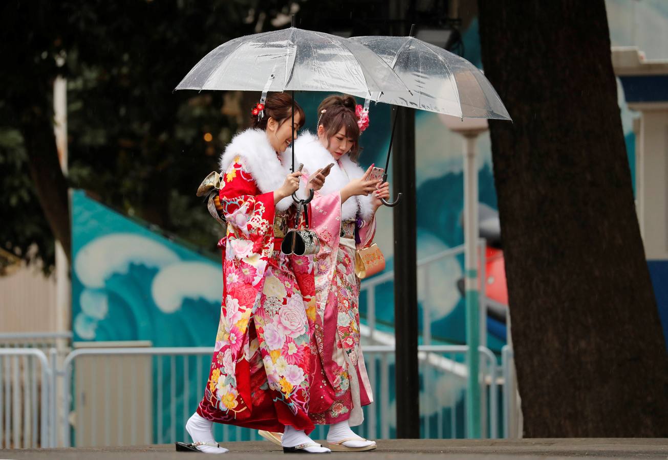 Mujeres japonesas vestidas con kimonos celebran la 'Ceremonia del Día de la mayoría de edad' en un parque de atracciones en Tokio, Japón.