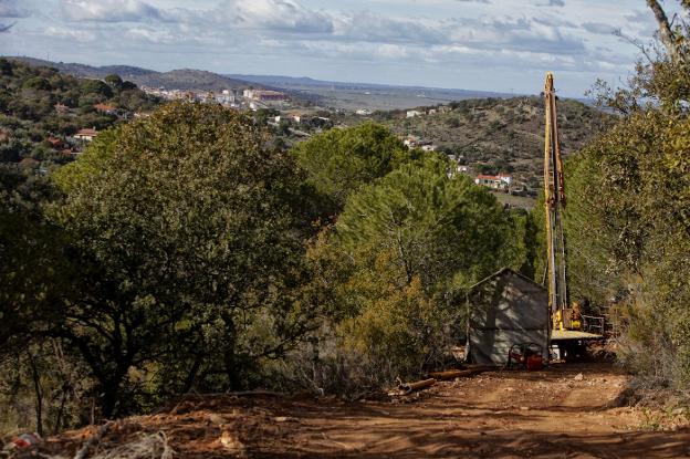 Una máquina perforadora en los trabajos previos de sondeos en la Montaña, con Cáceres al fondo. :: l.c.