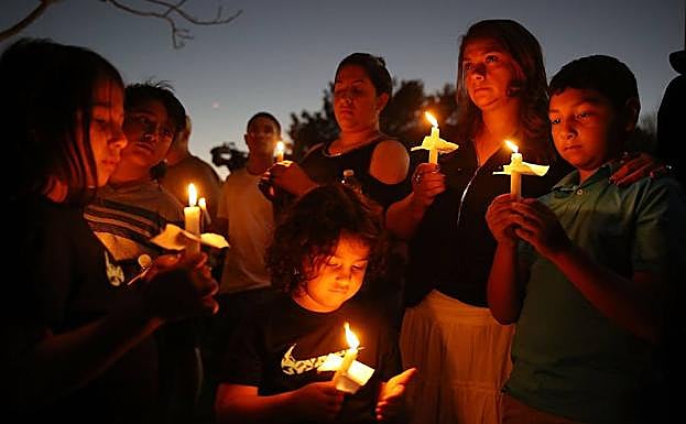 Varias personas portan velas en el velatorio de Parkland. 