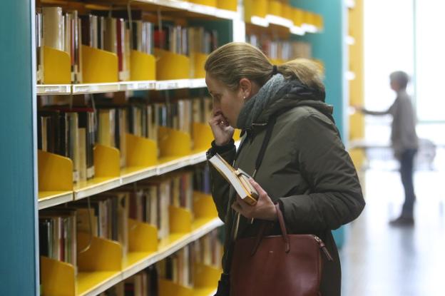 Una de las usuarias de la biblioteca de Mérida buscando libros. :: j. m. romero