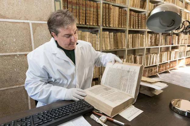 Gorka Díaz inspecciona uno de los cerca de 5.000 volúmenes de entre los siglos XVI y XVIII que se conservan en la biblioteca. :: andy solé