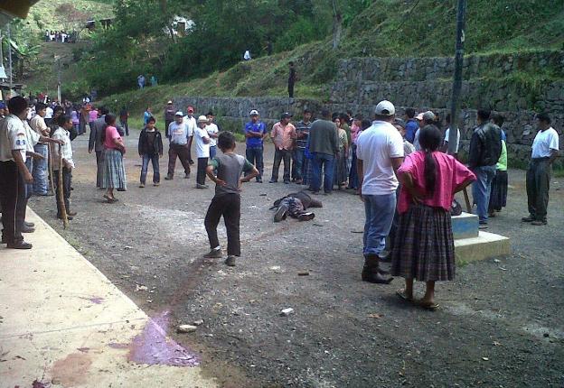 Vecinos de la localidad guatemalteca de Tactic observan el cuerpo de un asesino de niños linchado tras arrebatárselo a la Policía. Abajo, un ladrón es prendido fuego en Pelileo Grande, Ecuador. 