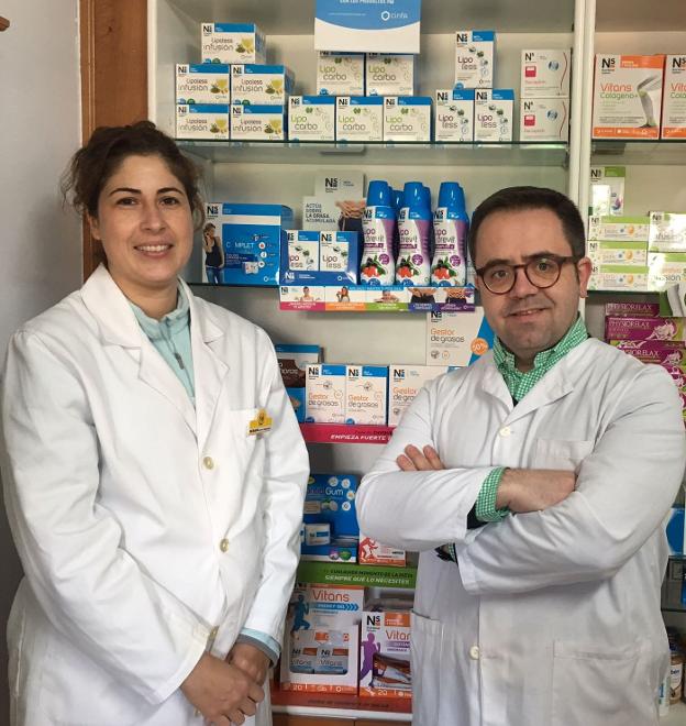 Fermín Jaraíz, en su farmacia de Guijo de Granadilla, junto a Susana Jiménez, auxiliar. :: hoy