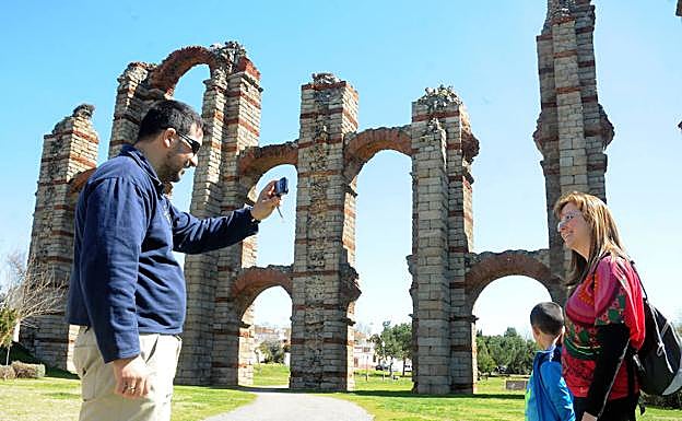 Una familia se hace fotos junto a los Milagros. 