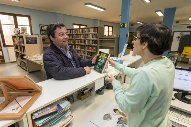 Un usuario de la Biblioteca Municipal de Plasencia toma en préstamo un libro. :: andy solé
