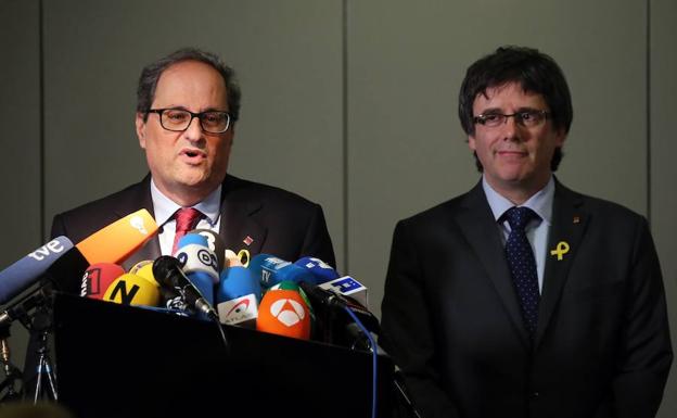 El recién elegido presidente de la Generalitat de Cataluña, Quim Torra (izq), hace una declaración a la prensa en presencia de su predecesor, el expresidente regional catalán Carles Puigdemont