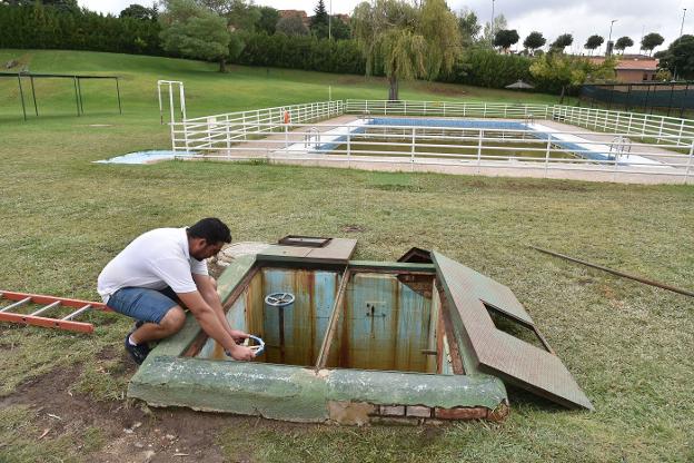 Un operario manipula el mecanismo de una de las piscinas de la Ciudad Deportiva. :: david palma