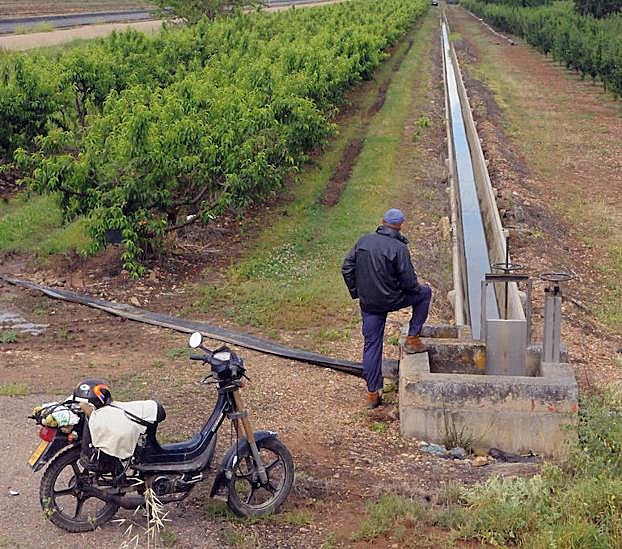 Un agricultor cerca de Lobón junto a una acequia con agua