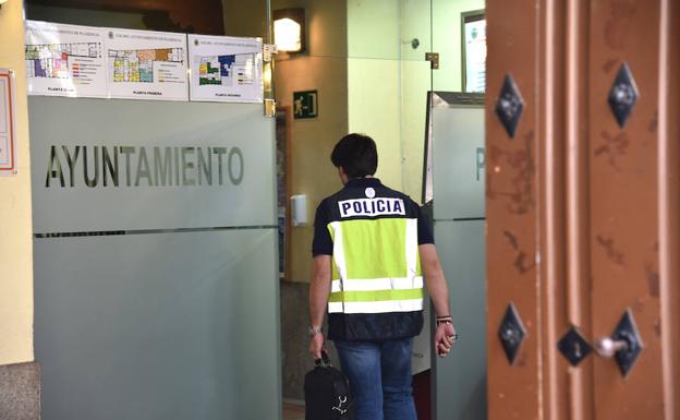 Un Policía Nacional del operativo entrando este martes por la mañana en el ayuntamiento de Plasencia. 