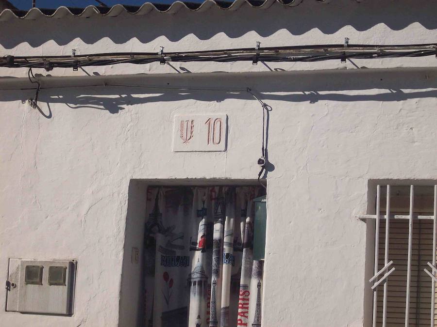 Placa de numeración de viviendas en Aldea Moret con el símbolo del Sindicato Vertical. 