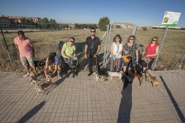 Varios vecinos con sus mascotas, ante la entrada del nuevo parque canino. :: JORGE REY