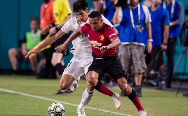 Jesús Vallejo, encimando a Alexis Sánchez. 