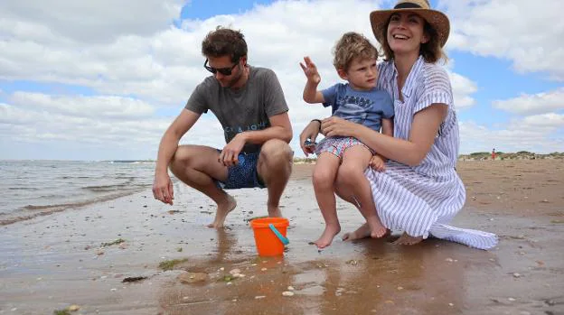 Enrique Callejo y Cristina Gallego, ambos de Badajoz, con Mateo, su único hijo, este verano en una de las playas de El Portil, en la costa de Huelva. :: Jlg