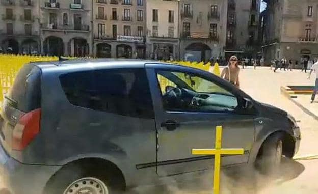 Un coche arrolla cruces amarillas por los políticos presos en la plaza de Vich. 