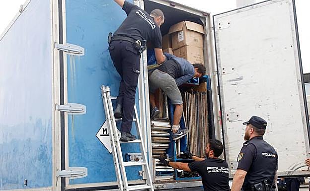 Los agentes ayudan a salir a un migrante oculto. 