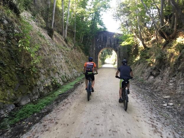 Dos ciclistas pedalean en uno de los varios tramos que discurren entre altas paredes de piedras. :: a.a.