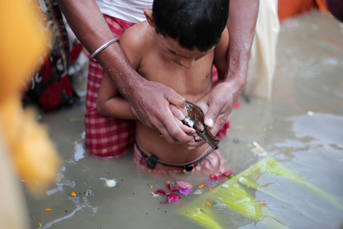 Ritual 'Tarpan' durante las oraciones de Mahalaya en las orillas del río sagrado Ganges en Calcuta, India oriental. Bengalíes de todo el mundo celebrarán el festival del 16 al 19 de octubre, que representa La victoria del bien sobre el mal y la celebración del poder femenino.