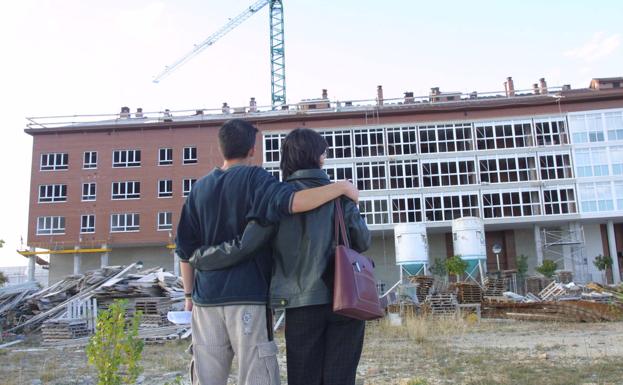 Una pareja de jóvenes contempla viviendas en construcción.
