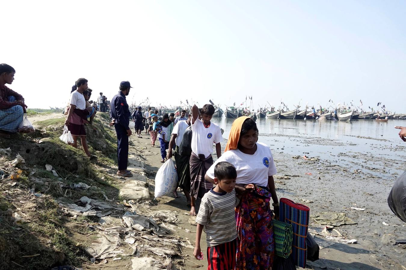 Policías birmanos escoltan al grupo de 106 rohinyás de vuelta a Sittwe en el estado de Rakáin (Birmania). El pasado 16 de noviembre, el barco en el que viajaban los 106 rohinyás encalló en la costa cerca de Rangún, con uno de sus ocupantes muerto, cuando trataba de llegar a Malasia. 