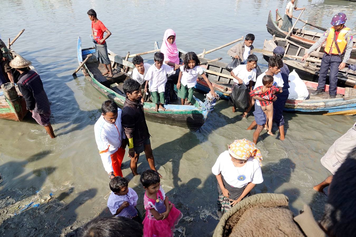 Policías birmanos escoltan al grupo de 106 rohinyás de vuelta a Sittwe en el estado de Rakáin (Birmania). El pasado 16 de noviembre, el barco en el que viajaban los 106 rohinyás encalló en la costa cerca de Rangún, con uno de sus ocupantes muerto, cuando trataba de llegar a Malasia. 