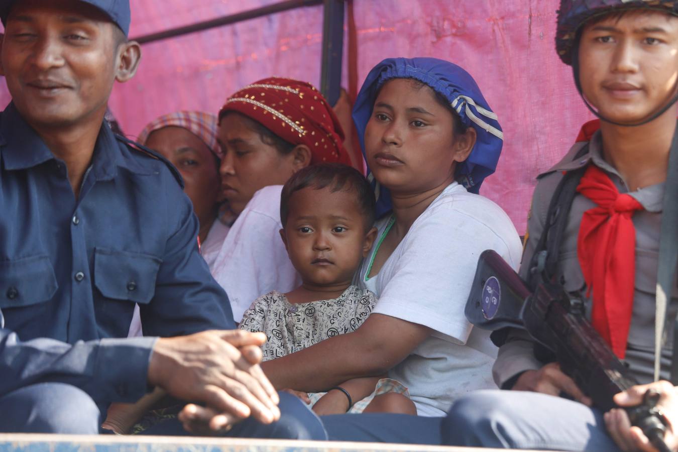 Policías birmanos escoltan al grupo de 106 rohinyás de vuelta a Sittwe en el estado de Rakáin (Birmania). El pasado 16 de noviembre, el barco en el que viajaban los 106 rohinyás encalló en la costa cerca de Rangún, con uno de sus ocupantes muerto, cuando trataba de llegar a Malasia. 