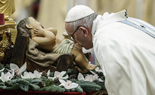 El papa Francisco besa la figura del niño Jesús. 