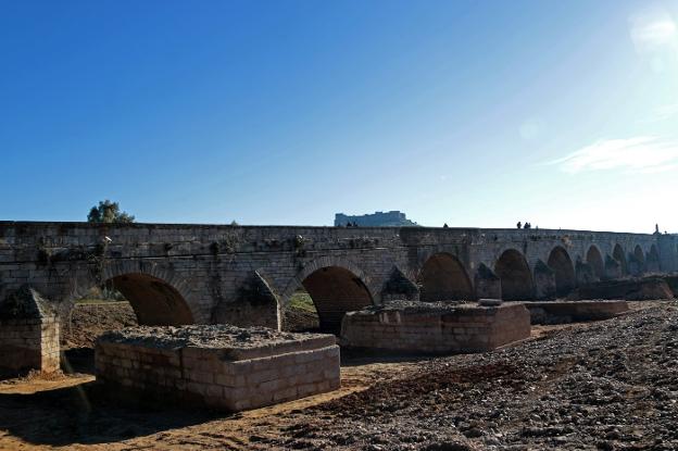 Los pilares encontrados, junto al puente de Felipe IV, y de fondo el castillo de Medellín. :: e. domeque