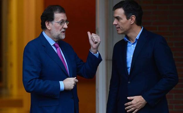 Rajoy (i) habla con Pedro Sánchez. 