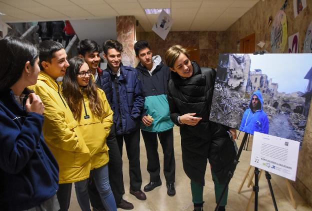 Mamen Tena muestra una fotografía a varios alumnos. :: c. moreno