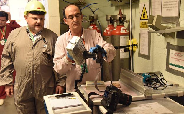 Un operario comprueba la radiación de varios objetos, antes de que salgan del edificio del reactor.