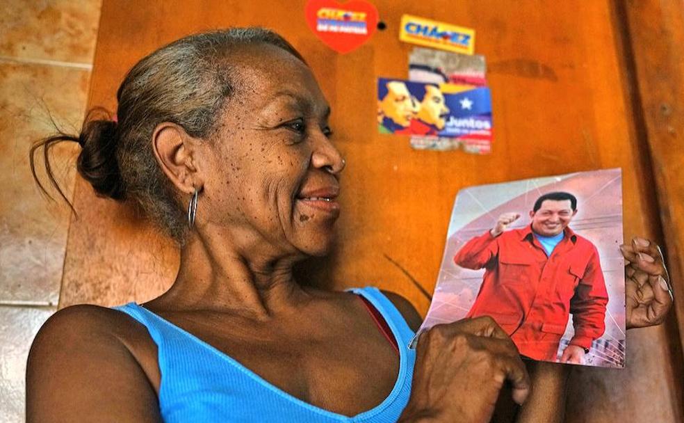 Carmen posa junto a una foto de su querido Chávez. 