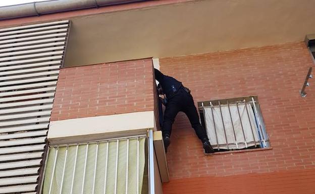 Uno de los agentes intenta acceder al balcón de la vivienda.
