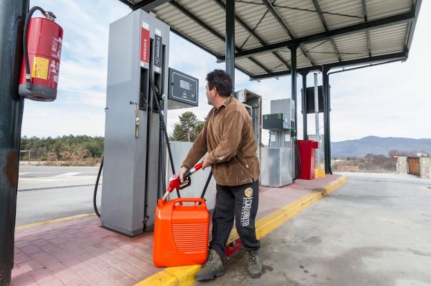 Un operario llena una garrafa de combustible en una cooperativa en el valle del Jerte. :: A. Solé