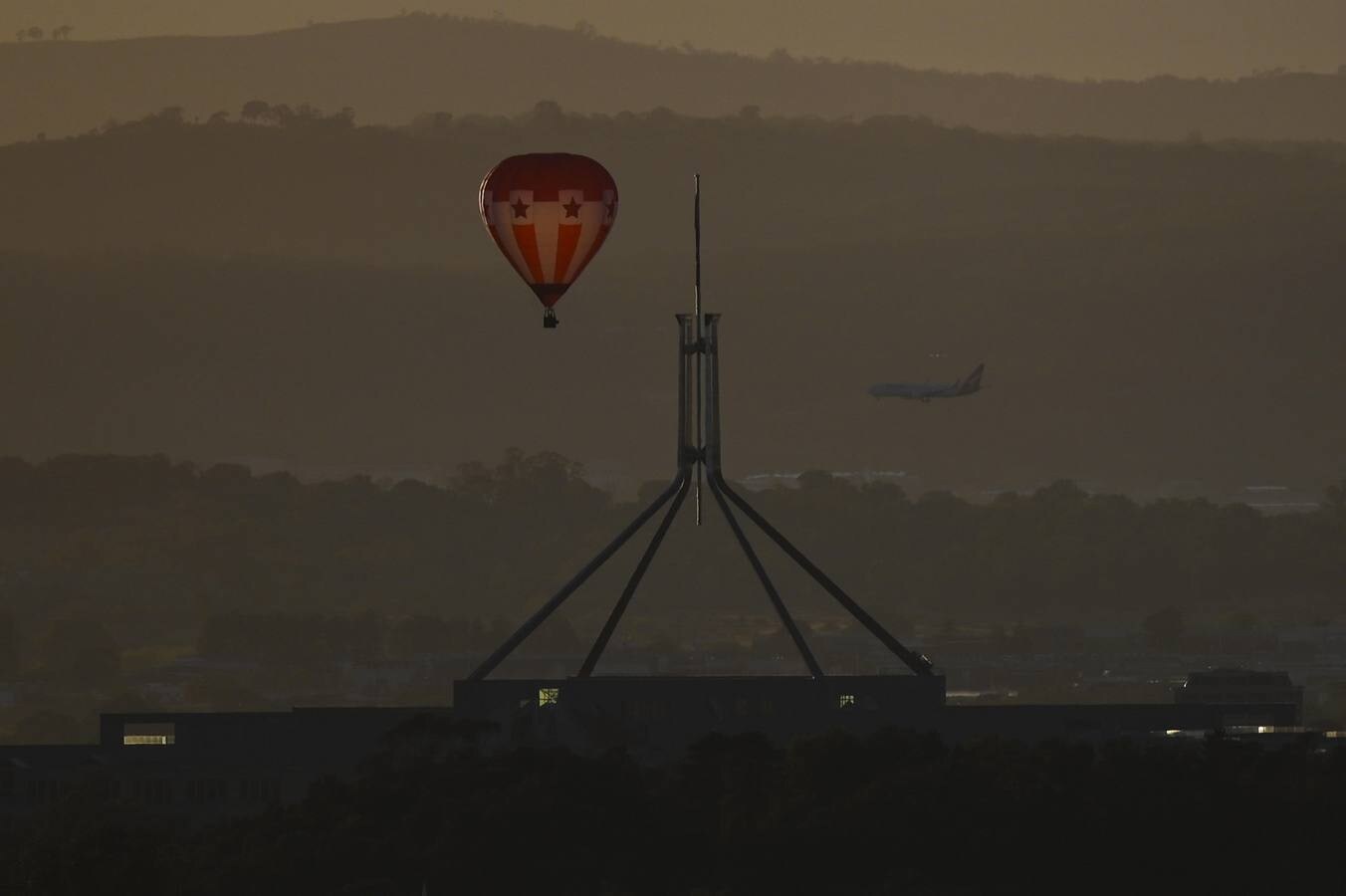 Observan cómo los globos aerostáticos se elevan sobre el lago Burley-Griffin durante el festival internacional de globos de Camberra, Australia. El festival es considerado como uno de los más grandes del mundo.