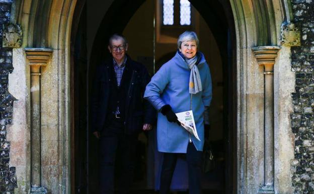 Theresa May y su marido, Philip, salen de la iglesia de Sonning este domingo.